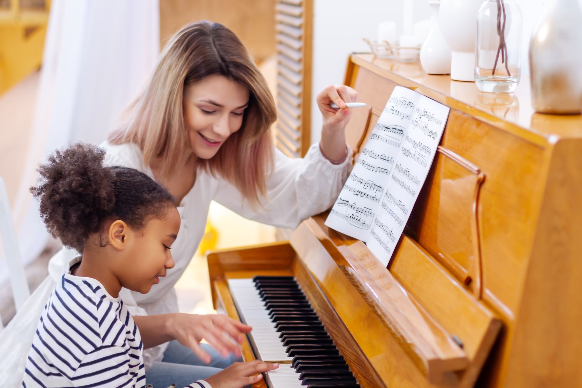 Teacher pianist gives piano classes to a young little student